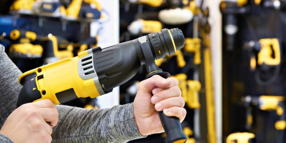 Hammer drill in man's hands closeup